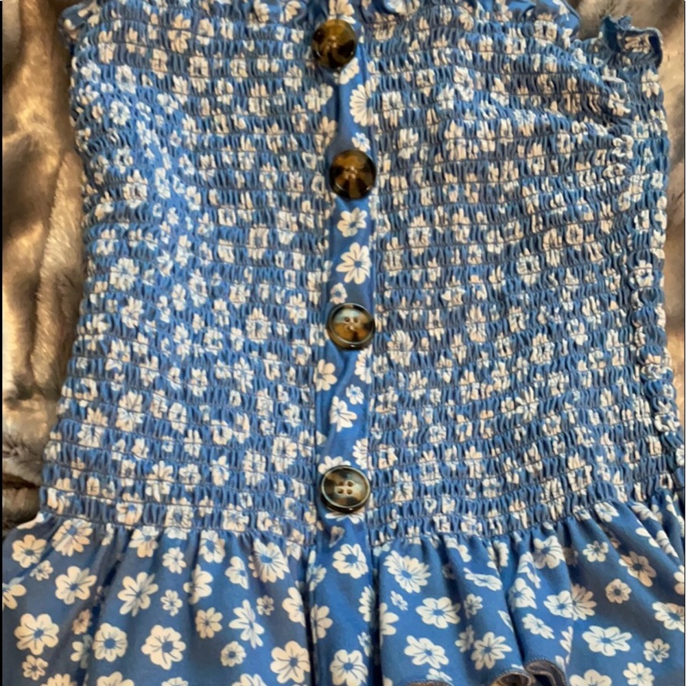 A blue strapless top with white flowers.